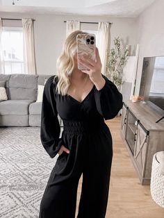 Our Working Gal Jumpsuit features a true black material, v-neckline with surplice front and snap button closure detail, long sleeves with elastic cuffs, smocked waistline, side pockets, wide leg pants with generous room. Approximately 29" inseam Model is 5'1", 34DD, 6-8/28 and is wearing a size small. Item runs slightly big - model sized down one from normal. If larger chest stick with true size. Also shown a 5'9" model in size small for a taller reference. More details: 100% polyester. hand was Black Long Sleeve Jumpsuit With Button Closure, Black Jumpsuit, Smocking, Wide Leg Pants, Wide Leg, Jumpsuit, Long Sleeve, How To Wear, Black