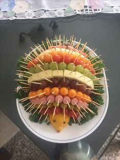 a platter filled with fruits and vegetables on skewers