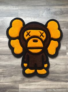 a rug with a cartoon monkey on it's face and eyes, sitting on a wooden floor