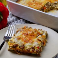 a white plate topped with lasagna next to a casserole dish