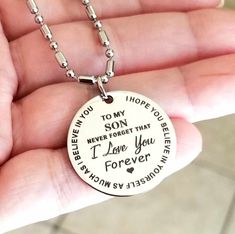 a person holding a necklace that says, i love you forever and the words on it