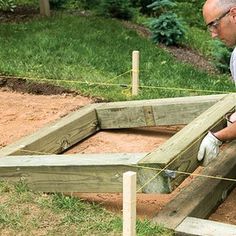 a man working on building a raised garden bed