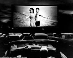 an old photo of two women in swimsuits on a large screen at a movie theater