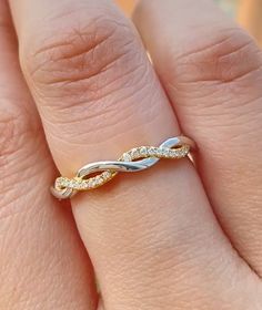 a woman's hand with a gold and white diamond ring on top of her finger