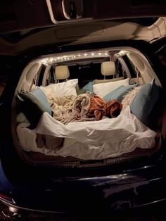 the trunk of a car filled with blankets and pillows