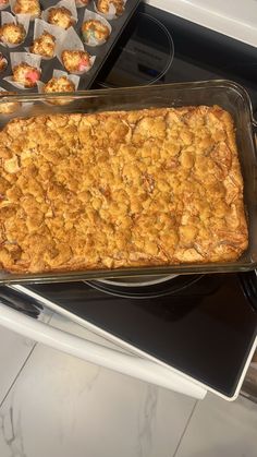 a casserole dish sitting on top of a stove next to muffin tins