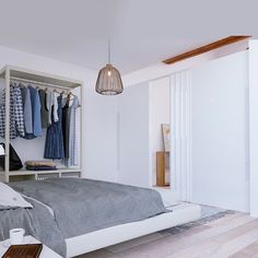 a bedroom with a bed, closet and clothes on hangers next to each other