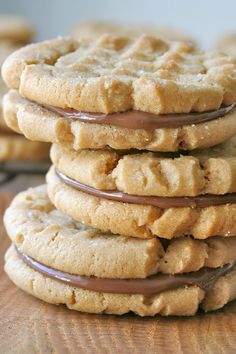 a stack of cookies sitting on top of a wooden table with chocolate drizzle