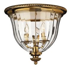 a light fixture with clear glass and gold trimmings on the top of it