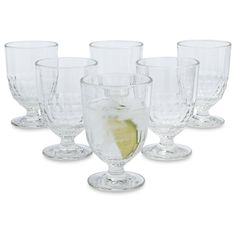 a set of six clear wine glasses with a lemon slice on the rim and bottom