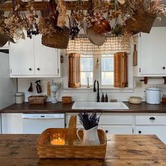 a kitchen with white cabinets and wooden counter tops