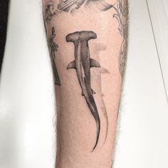 a man's leg with a shark and bird tattoo on the side of his arm