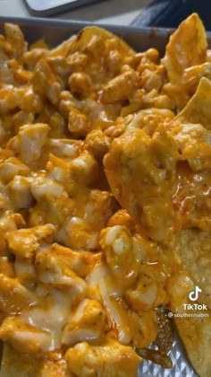 a man sitting in front of a large tray filled with macaroni and cheese