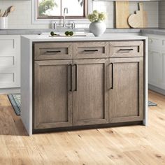 a kitchen with wooden floors and white cabinets