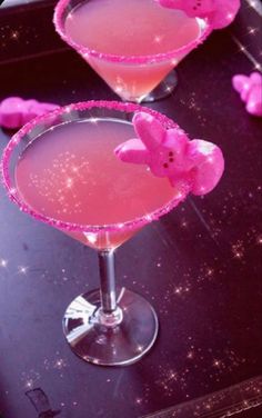 two glasses filled with pink liquid sitting on top of a black table next to each other