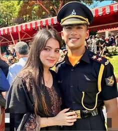 a man in uniform standing next to a woman