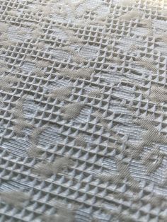 closeup of white fabric with small squares on it