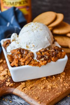 a scoop of ice cream sitting on top of a wooden cutting board next to crackers