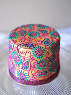 a brightly colored cake sitting on top of a glass plate