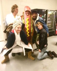 a group of people standing around a giant hot dog