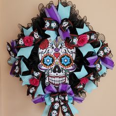 a colorful wreath decorated with skulls and roses on a wall in the day of the dead