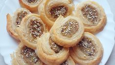 a white plate topped with pastry covered in sesame seeds