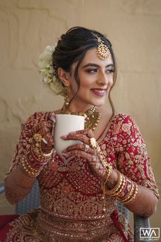 a woman in a red and gold outfit holding a cup