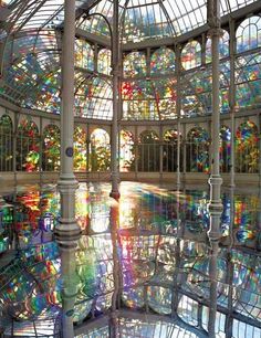 the inside of a building with many stained glass windows and columns in front of it