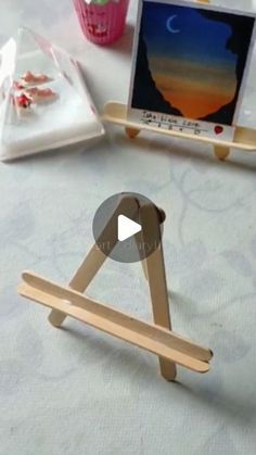 a small wooden easel sitting on top of a table next to a laptop computer