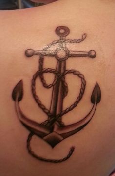 an anchor tattoo on the back of a woman's stomach, with ropes and anchors