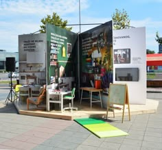 an outdoor display with chairs, tables and signs