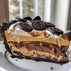 an oreo cookie dessert on a white plate with a window in the back ground