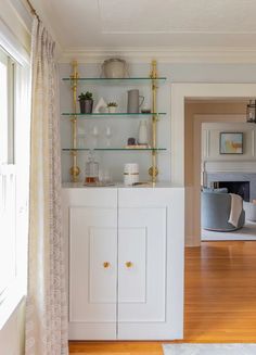 a living room filled with furniture and lots of shelves on top of each other in front of a window