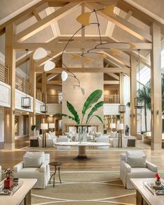 a large living room filled with white furniture and lots of wood beams on the ceiling