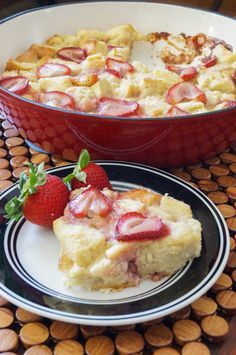 a piece of strawberry cobbler on a plate next to a bowl of strawberries