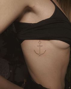 an anchor tattoo on the side of a woman's lower back ribcage