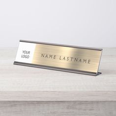 a metal name plate sitting on top of a wooden table