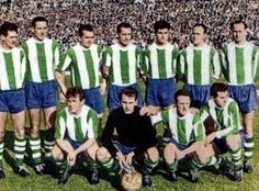 a group of men standing next to each other in front of a soccer ball on a field