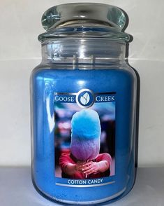 a close up of a blue candle with a picture on the front and side of it