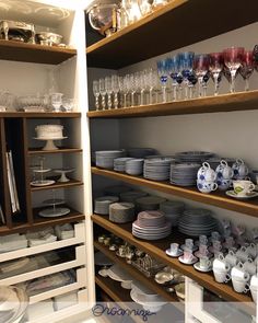 the shelves are filled with dishes and glasses