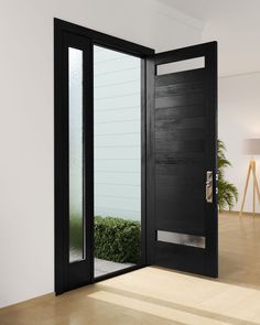 an open black door in a white room with wood flooring and potted plants