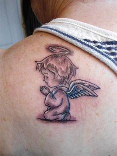 a small angel tattoo on the back of a woman's upper arm and shoulder