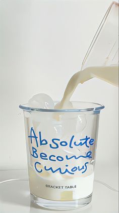 a glass filled with milk being poured into a container that reads absolute becoming geniuses