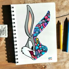 a drawing of a cartoon rabbit with flowers on it's head, next to colored pencils