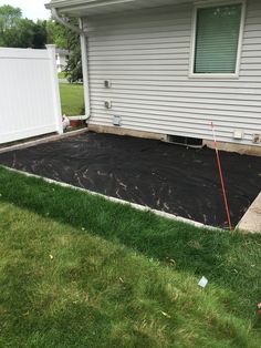 the back yard is covered with black tarp and ready to be used as an in ground pool