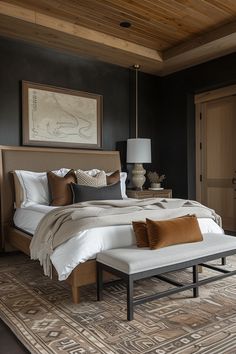 a large bed sitting on top of a wooden floor next to a dresser and lamp