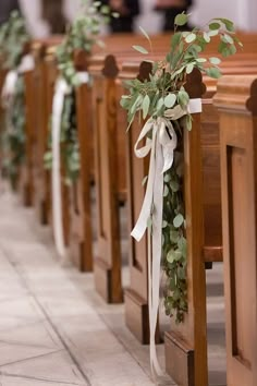 rows of wooden pews decorated with greenery and ribbons