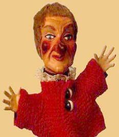 an image of a creepy doll that appears to be wearing a red sweater and holding his arms out