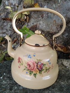 an old tea kettle with flowers painted on it