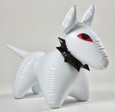 an inflatable white dog with red eyes and a black bow on its neck